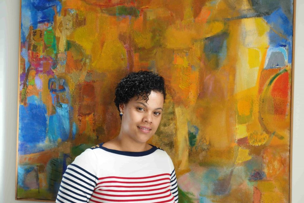 light skinned African American woman wearing a striped white, blue and red sweater