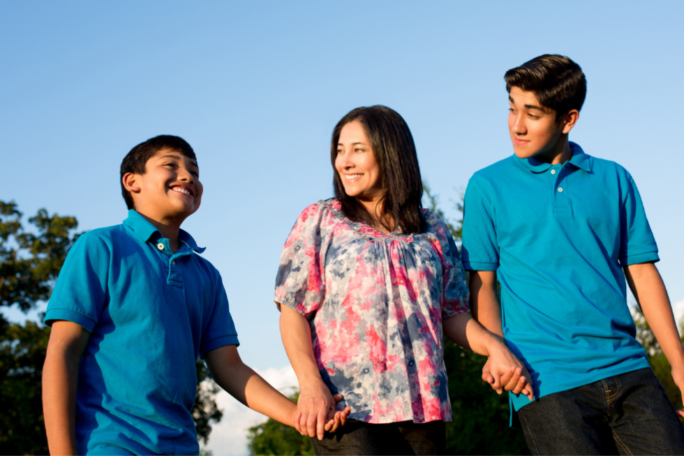 Mom with two sons smiling outside