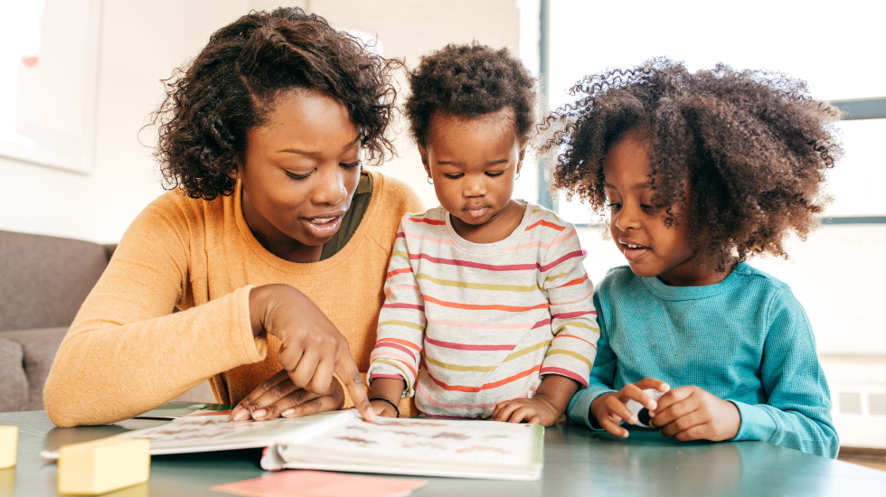 A mother reads with her two young children